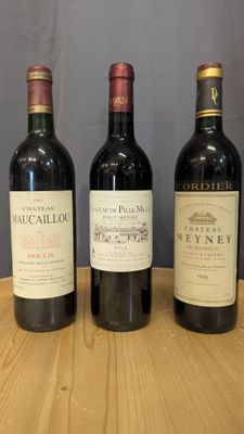 trois bouteilles de vin sont alignées sur une table en bois