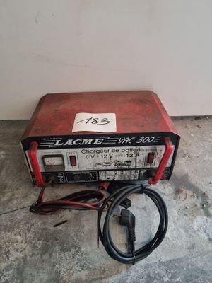 une image représentant une machine rouge et noire posée sur un sol en béton