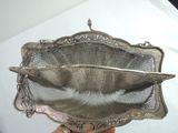 a person holding a silver metal strainer in their hand