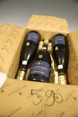 trois bouteilles de vin dans un coffret sur une table