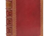 un vieux livre à la couverture rouge et à la bordure dorée