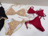 several different types of bikinis on a table with price tags on them