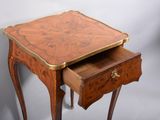 a small wooden table with a drawer underneath it