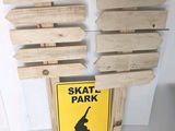a skate park sign on the wall next to a skateboard sign