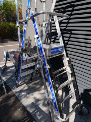 two ladders that are leaning against a building
