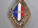 une image représentant un insigne sur lequel figure le mot « ONU »