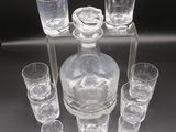 many glasses and a decanter sitting on a table