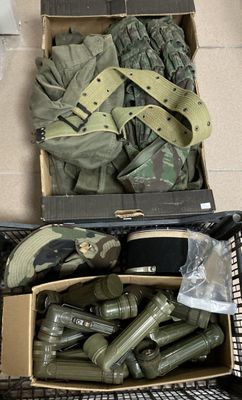 une boîte remplie d'objets militaires posée par terre