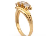 a close up of a gold ring with three diamonds on it