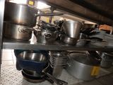 de nombreuses casseroles et poêles sur l'étagère de la cuisine