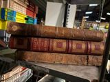 plusieurs vieux livres sont empilés sur une étagère