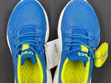 a close up of a pair of blue and yellow shoes on a black surface