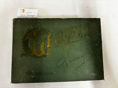 an old green book with gold lettering sitting on top of a white table