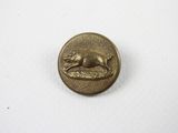 un petit bouton en bronze sur lequel est représenté un chat