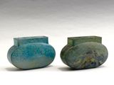 deux vases posés l'un à côté de l'autre sur une surface blanche