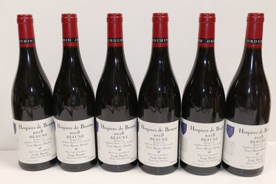 six bouteilles de vin rouge sont alignées sur une table