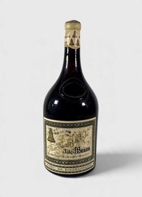une vieille bouteille d'alcool posée sur une surface blanche