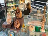 a glass display case filled with wooden figurines in a store