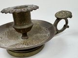 a metal candle holder with a candle on top of it