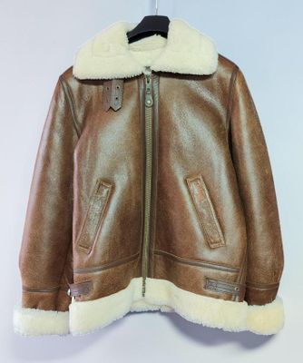 une veste en cuir marron suspendue à un cintre sur un mur blanc
