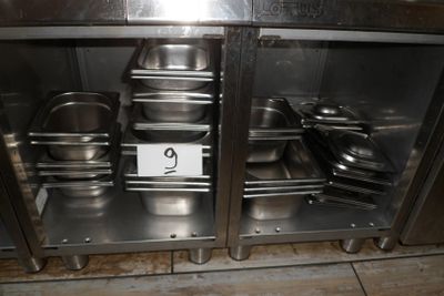 de nombreuses casseroles et poêles rangées dans un placard en inox