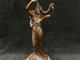 statue en bronze représentant une femme tenant un vase, posée sur un socle en marbre