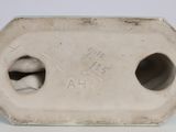 a white vase with two holes in it on a table