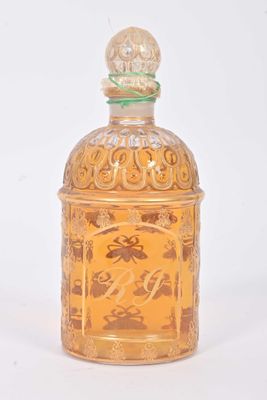 une petite bouteille en verre ornée d'un motif doré