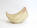 a small yellow bowl sitting on a white surface