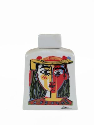 a picture of a bottle of perfume with a woman ' s face painted on it