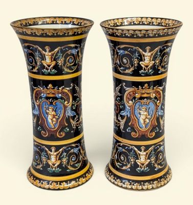 une paire de vases noirs et dorés, ornés de motifs sur fond blanc