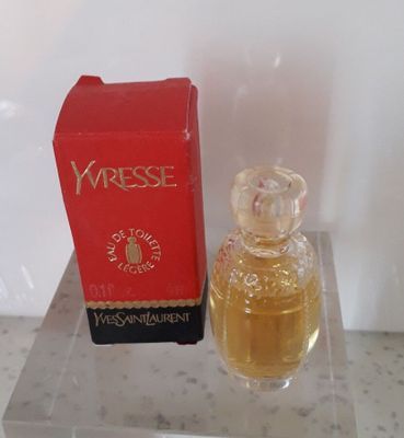 un flacon de parfum posé sur une table à côté d'une boîte de parfum