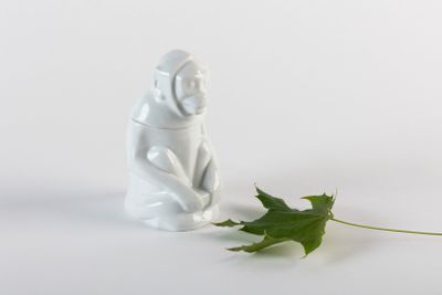 une figurine représentant un singe assis à côté d'une feuille