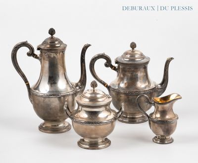 five silver teapots and two cups on a table