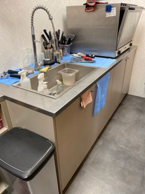 a kitchen with a sink and a trash can in it