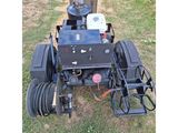 an image of a lawn mower sitting on top of a grass covered field