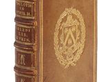 un vieux livre relié en cuir, orné d'un emblème doré sur la couverture