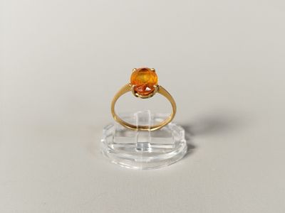 a close up of a gold ring with an orange stone on it