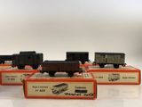 four toy trains are lined up in boxes on a white surface