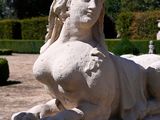 a statue of a woman laying on a bench in a park