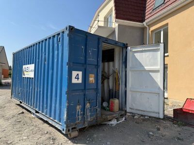 a blue shipping container sitting outside of a house
