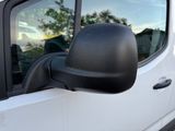 a side view mirror of a white truck with a reflection of a tree in the window