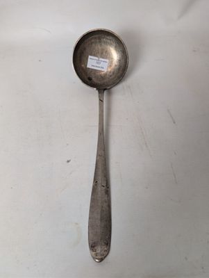 an old spoon with a sticker on it sitting on a table