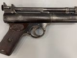 un vieux pistolet posé sur une table, sur fond blanc