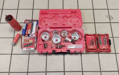 a pink tool case with tools in it on a tiled floor