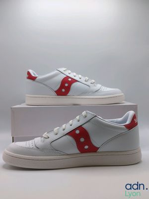a pair of white sneakers with red and white stripes