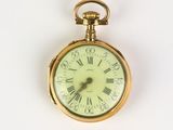 a gold pocket watch with roman numerals on it