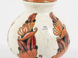 un vase blanc orné de motifs orange et noirs