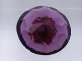 a glass bowl with a purple flower inside of it