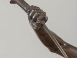 bronze statue of a man holding a sword and a sword in his hand